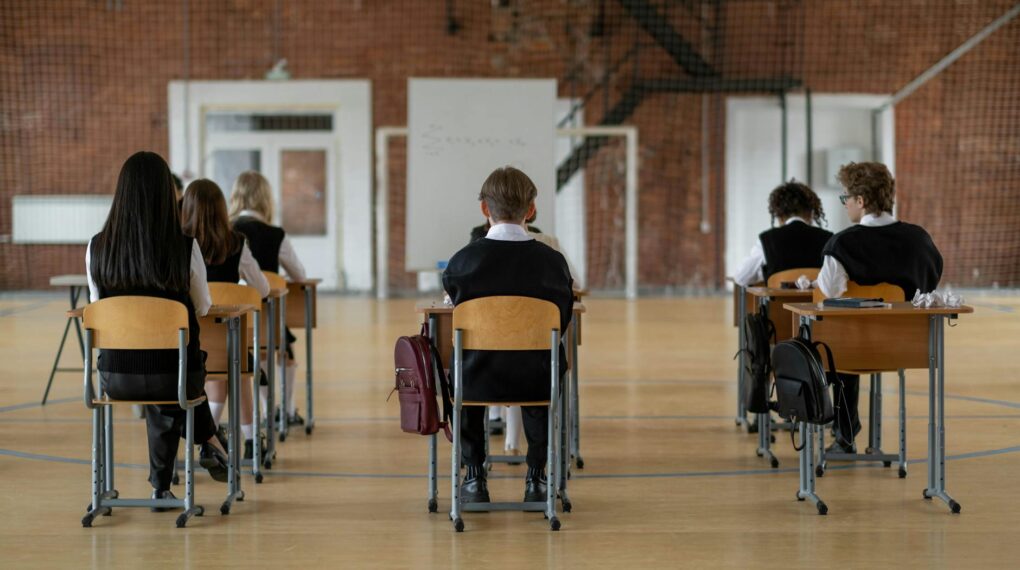 back view of the students sitting inside the classroom